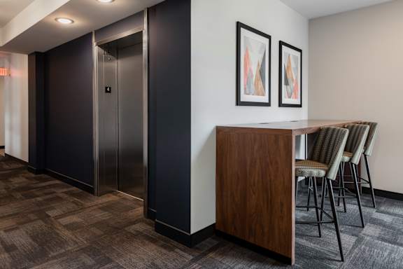 A room with a wooden cabinet and chairs.