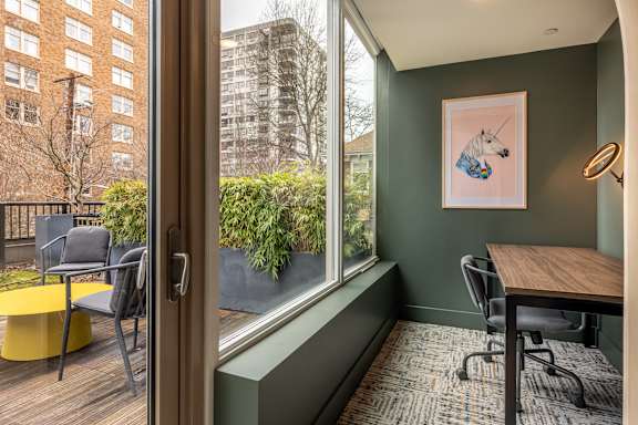 A room with a table and chairs and a picture of a horse on the wall.