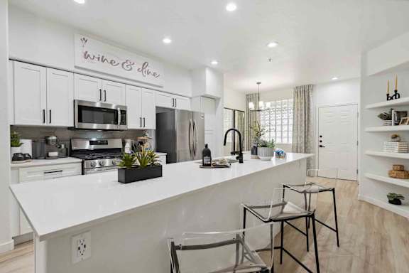A modern kitchen with a white countertop and a sign that says "Wine & Dine".