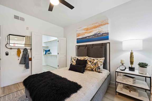 A bedroom with a large bed and a painting on the wall.