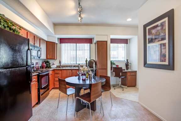 A kitchen with a table and chairs in the middle of the room.