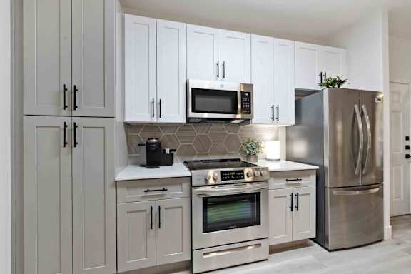A modern kitchen with stainless steel appliances and white cabinets.