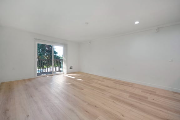 a bedroom with hardwood floors and white walls at The Crest at Citrus Heights Apartments, California