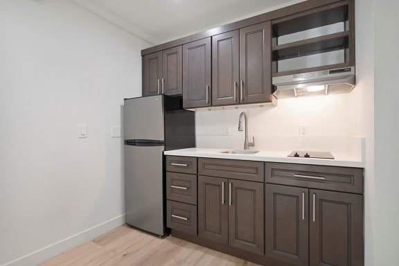 a kitchen with dark cabinets and white countertops at Citrus Heights Apartments, Citrus Heights, CA