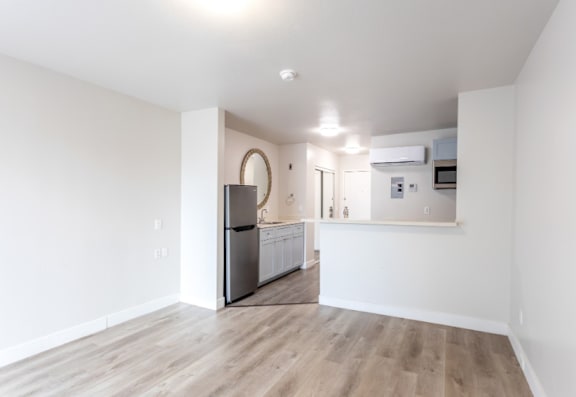 A kitchen with a refrigerator, microwave, and oven.