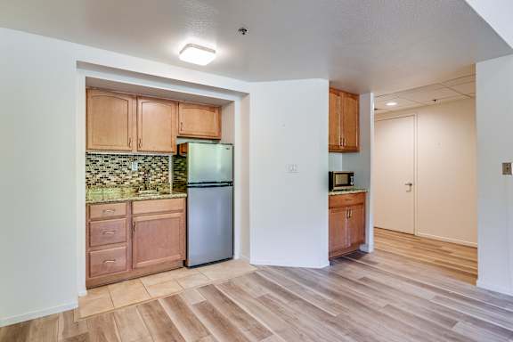 A kitchen with wooden cabinets and a green backsplash.