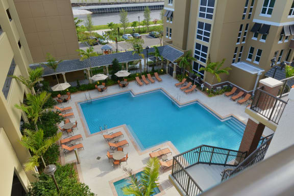 an overhead view of a resort style pool with lounge chairs and umbrellas at One Plantation, Plantation, FL