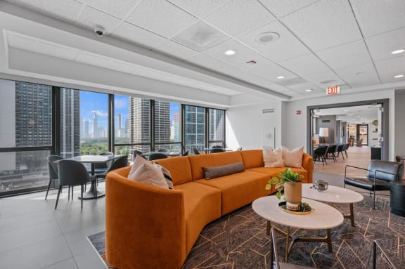 a living room with a couch and tables in front of a window at Shoreham and Tides, Chicago, 60601