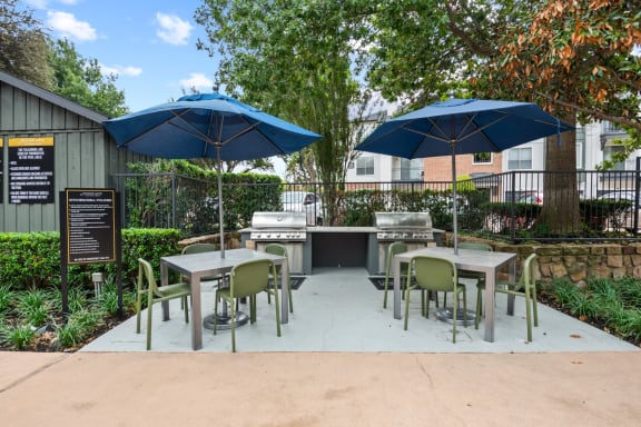 a patio with tables and chairs with umbrellas