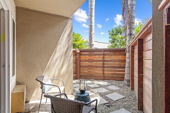 a patio with two chairs and a fire hydrant in front of a wooden fence at Veranda La Mesa, California