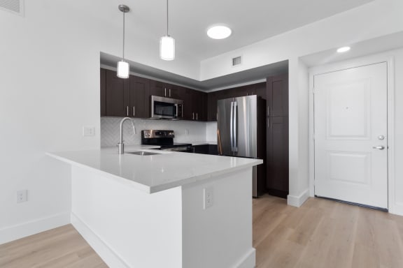 a kitchen with an island and a stainless steel refrigerator at One Plantation in Plantation, 33324