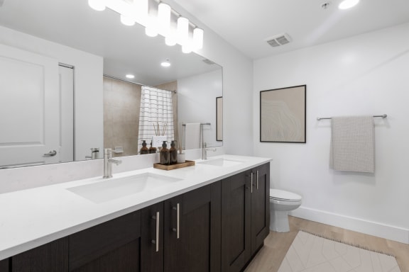 a bathroom with a sink and a toilet and a mirror at One Plantation in Plantation, Florida