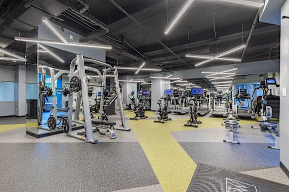 a gym with weights and cardio equipment in a building at The Citizen at Shirlington Village in Arlington, VA 22206