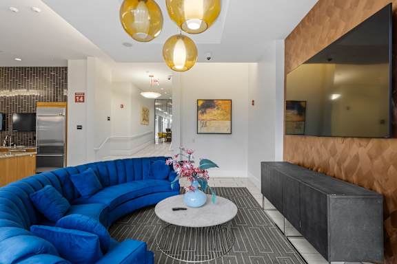 A blue sofa with a white coffee table in front of a mirror.