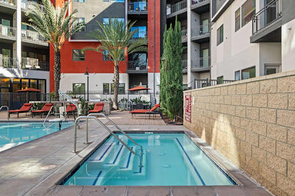 A small pool in a courtyard surrounded by buildings.