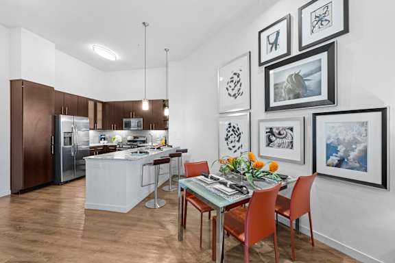 A kitchen with a dining table and chairs.