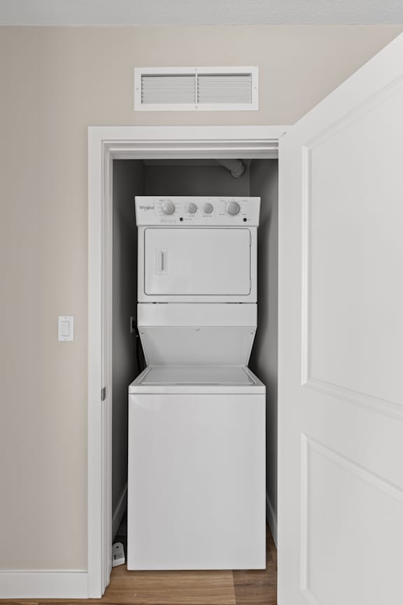 A white washing machine is built into a wall.