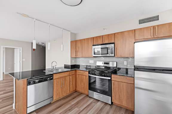 A modern kitchen with wooden cabinets and stainless steel appliances.