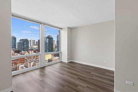 A room with a view of the city through large windows.