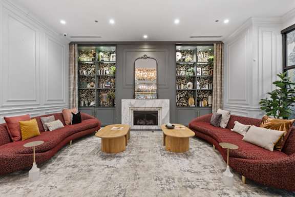A living room with a red couch and a fireplace.