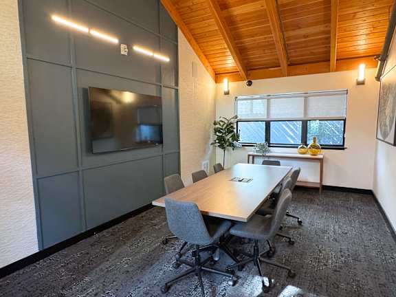 A conference room with a long table and chairs.