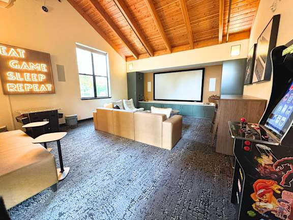 A room with a sign that says "Eat Game Sleep Repeat".
