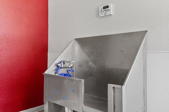 a stainless steel bathroom with a sink and a red wall at Verona, Littleton, CO