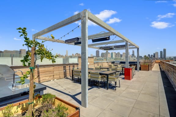a rooftop patio with tables and chairs and a view of the city at L Seven, San Francisco, California 94103