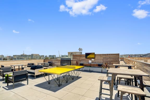 a rooftop patio with tables and chairs and a television at L Seven, San Francisco