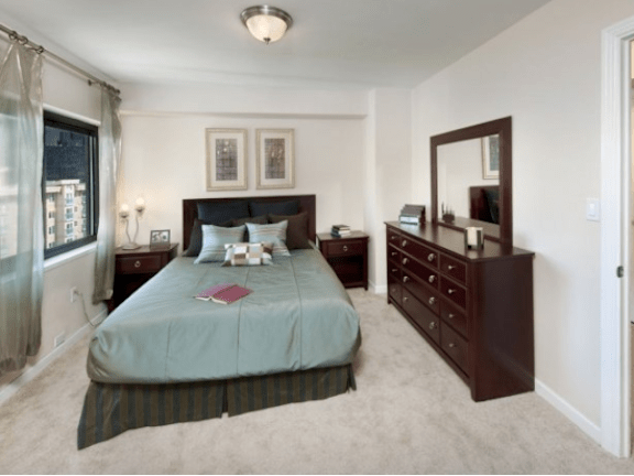 A bedroom with a bed, nightstand, and dresser at Skye at Belltown Apartments, Seattle, WA