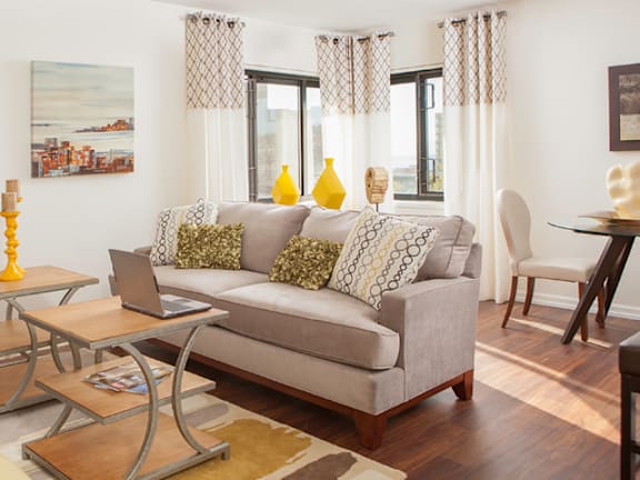 A living room with a grey couch, a coffee table, and a painting on the wall at Skye at Belltown Apartments, Seattle, Washington
