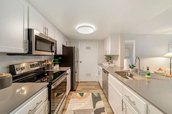A modern kitchen with stainless steel appliances and white cabinets. at Citrine Hills, Ontario, CA, 91761