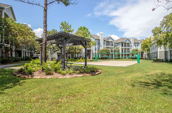 A tree-lined walkway leads to a building.
