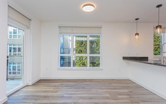 A room with a large window and a wooden floor.