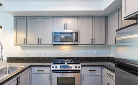 A modern kitchen with a stove top oven and microwave.