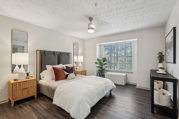A bedroom with a large bed and a wooden nightstand.