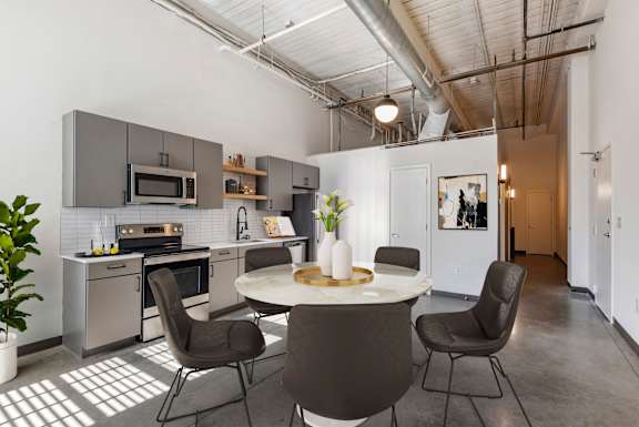 A modern kitchen with a dining table and chairs at Highland Mill Lofts, Charlotte