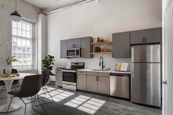 A modern kitchen with a large island and stainless steel appliances at Highland Mill Lofts, Charlotte, NC