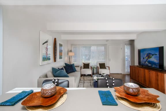 a breafast bar with the living room in the background with a couch and a table and a tv at Mala Grove, HI 96797