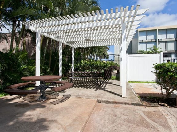 a patio with a picnic table and a pergola at Palms of Kilani in Wahiawa, HI
