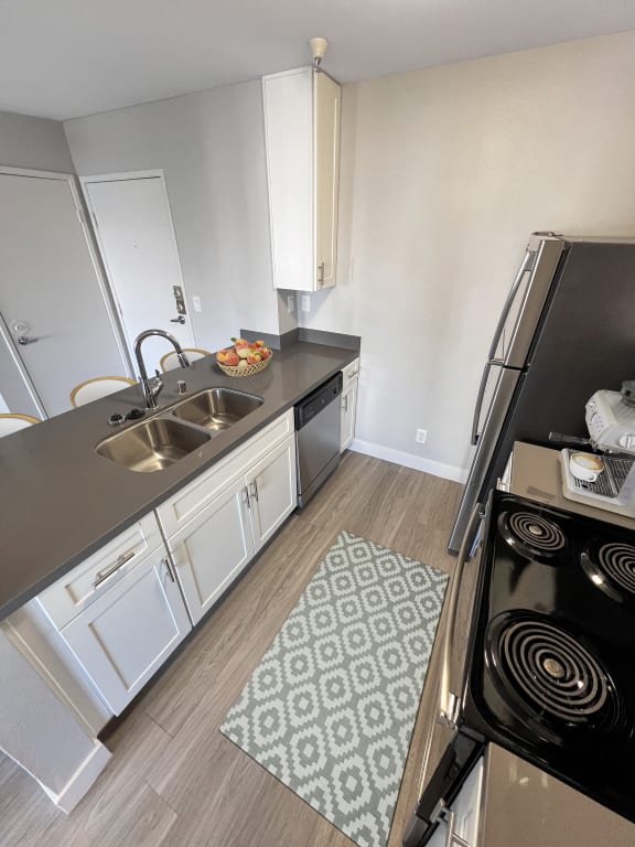 a kitchen with a sink and a stove and a refrigerator  at Duet on Wilcox, Los Angeles, 90028