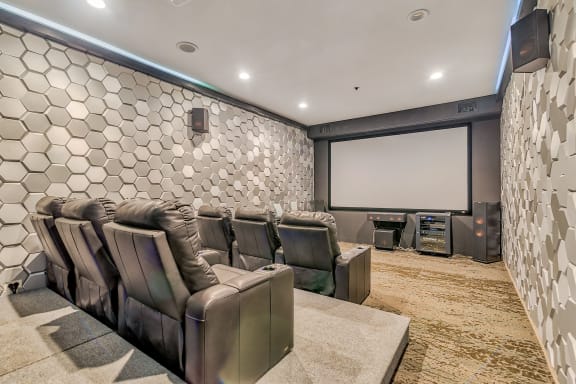 a cinema room with leather chairs and a projector screen at Avant at the Arboretum, IL 60532