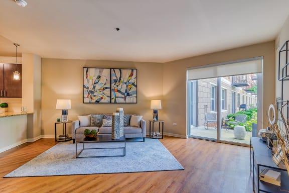 a living room with a large window and a table with chairs at Avant at the Arboretum, Lisle, 60532