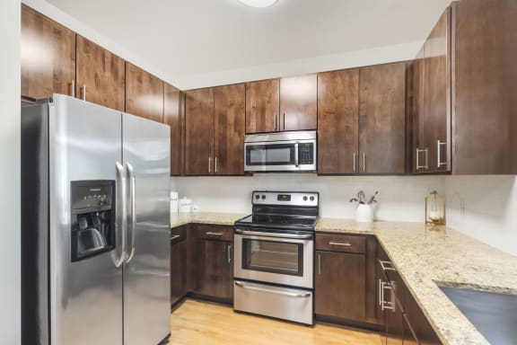 a kitchen with stainless steel appliances and wooden cabinets at Avant at the Arboretum, Illinois