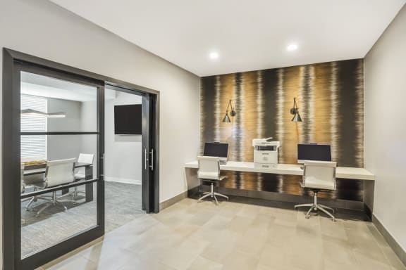 a conference room with desks and chairs and a glass door at Avant at the Arboretum, Lisle, 60532