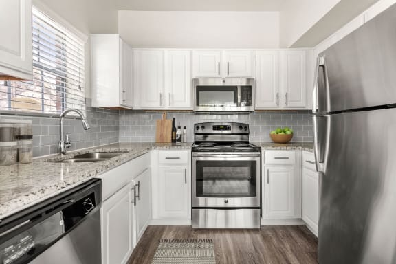 a kitchen with stainless steel appliances and white cabinets at Aston at Cinco Ranch, Katy, TX, 77450