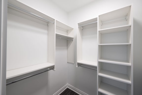 a walk in closet in a home with white walls and white shelving  at The Belden Stratford, Chicago, IL