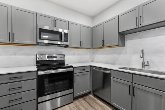 an empty kitchen with stainless steel appliances and white cabinets at Switchback on Platte Apartments, Colorado, 80120