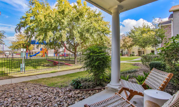 covered patio with chairs and playground  at Sladestone Shadow Creek in Pearland, 77584
