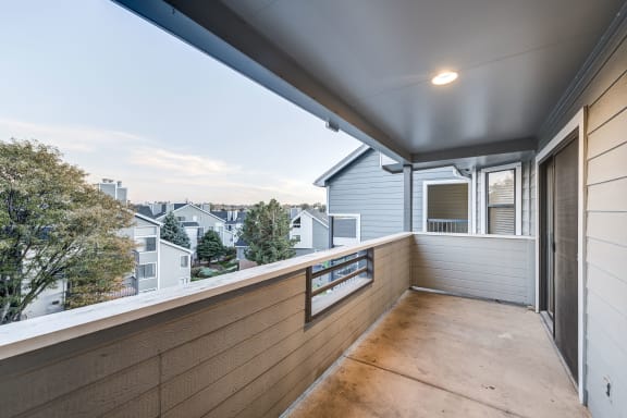 a balcony with a wood floor and a view of a city at Ashford Belmar Apartments, Colorado